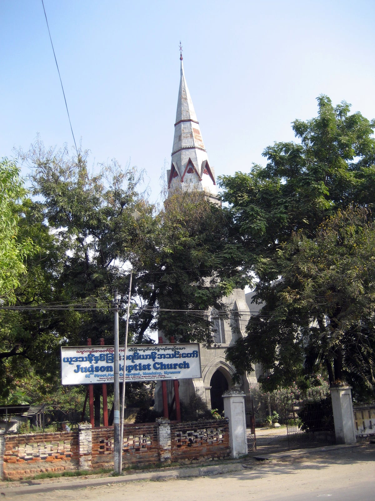 Judson Baptist Church in Mandalay, a Gothic-spired church behind a walled compound and trees.