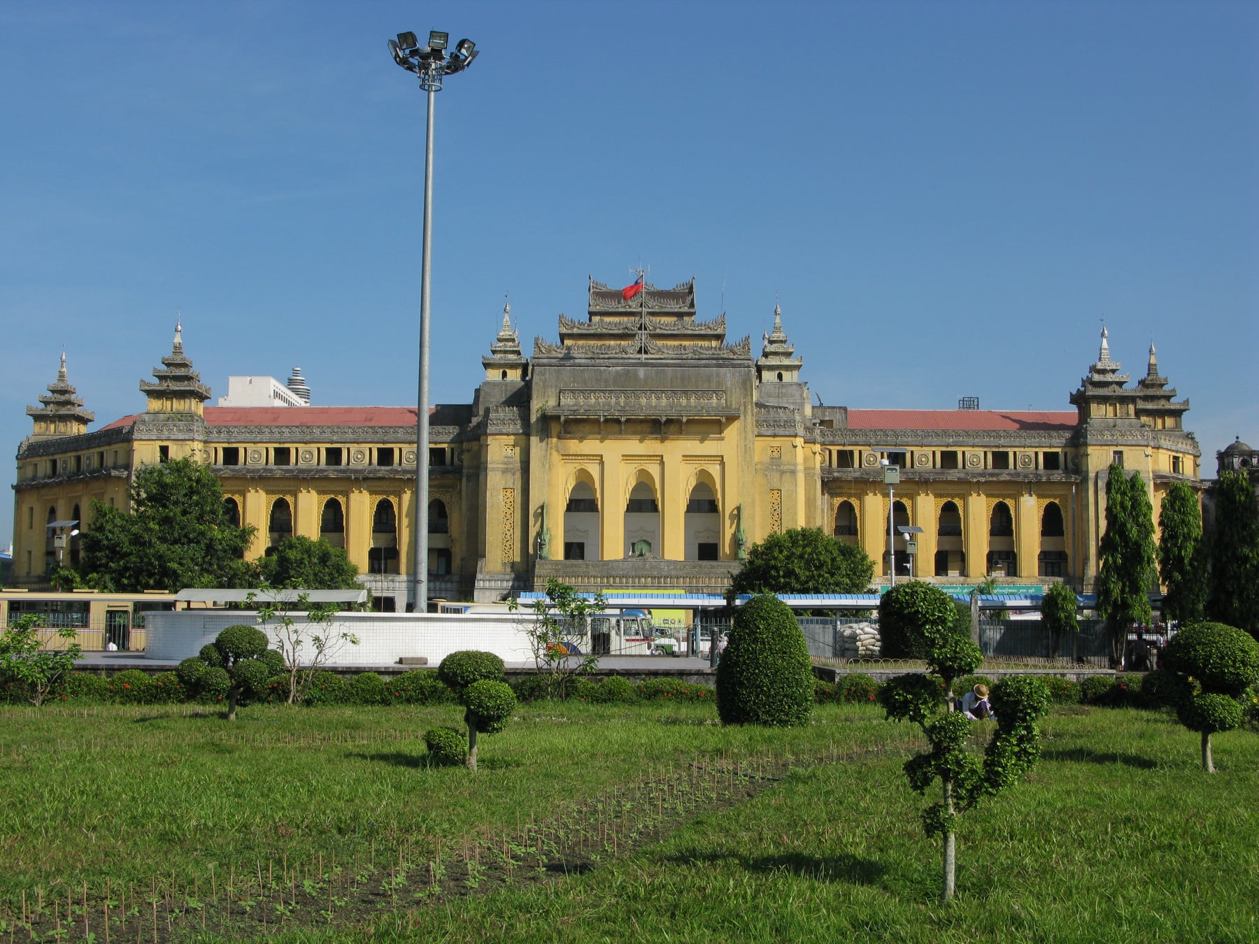 The yellow facade of Yangon City Hall, its European arches topped with a traditional tiered Burmese pyatthat roof.
