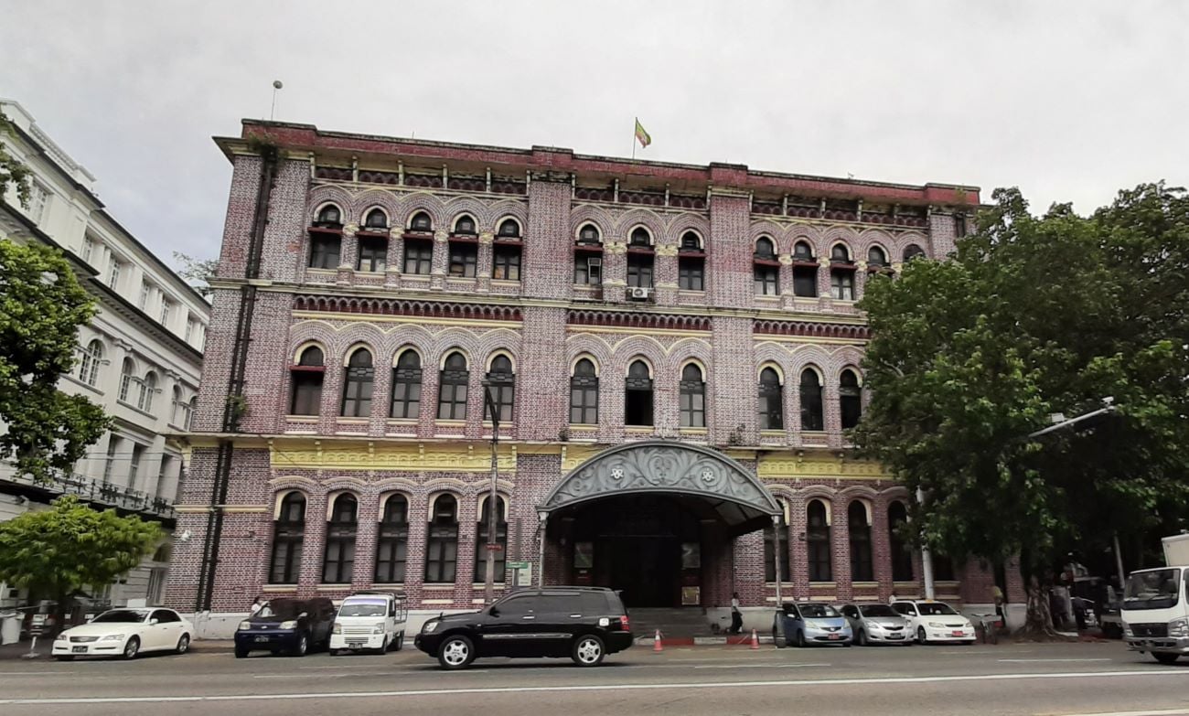 The red-brick facade of Yangon's General Post Office on Strand Road, with pointed-arch windows and a decorative entrance canopy.
