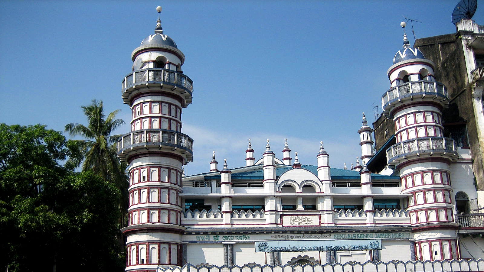 The twin domed minarets of the Bengali Sunni Jameh Mosque against a clear blue sky in downtown Yangon.