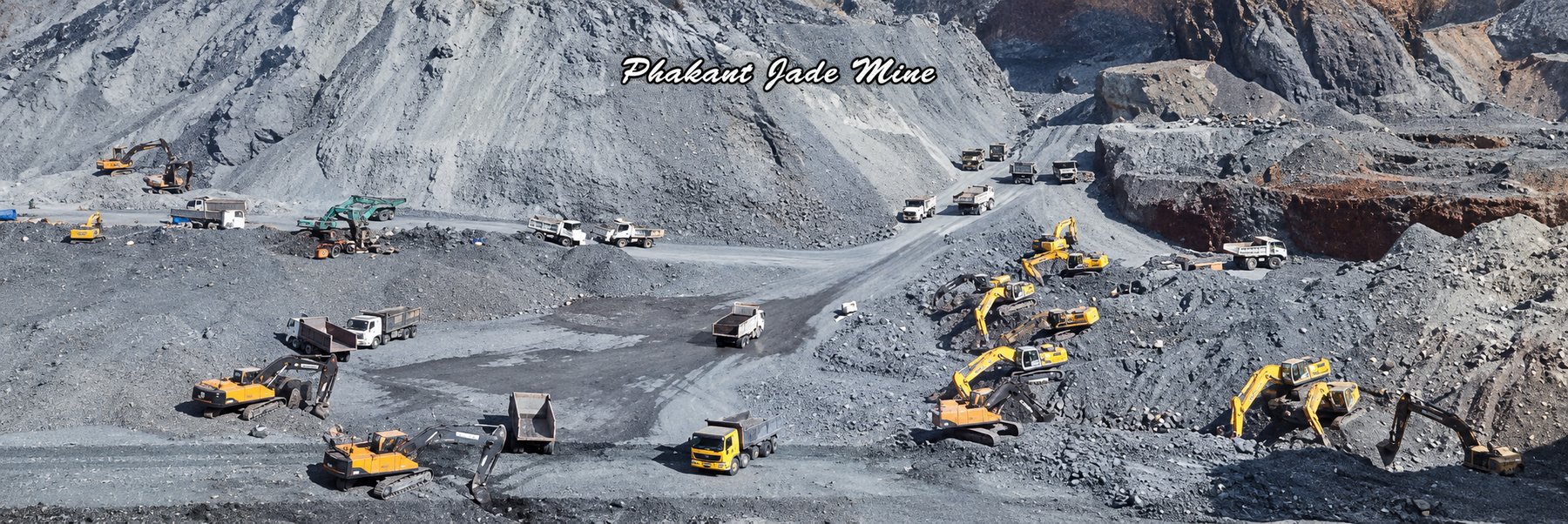 An aerial view of the Hpakant jade mine in Kachin State, with excavators and dump trucks working across a vast grey landscape of excavated rock.