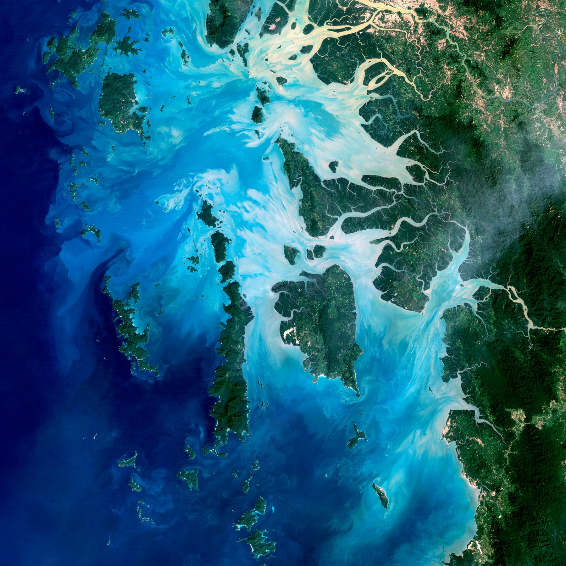 A satellite view shows hundreds of forested islands scattered across the turquoise and deep blue waters of the Myeik Archipelago.