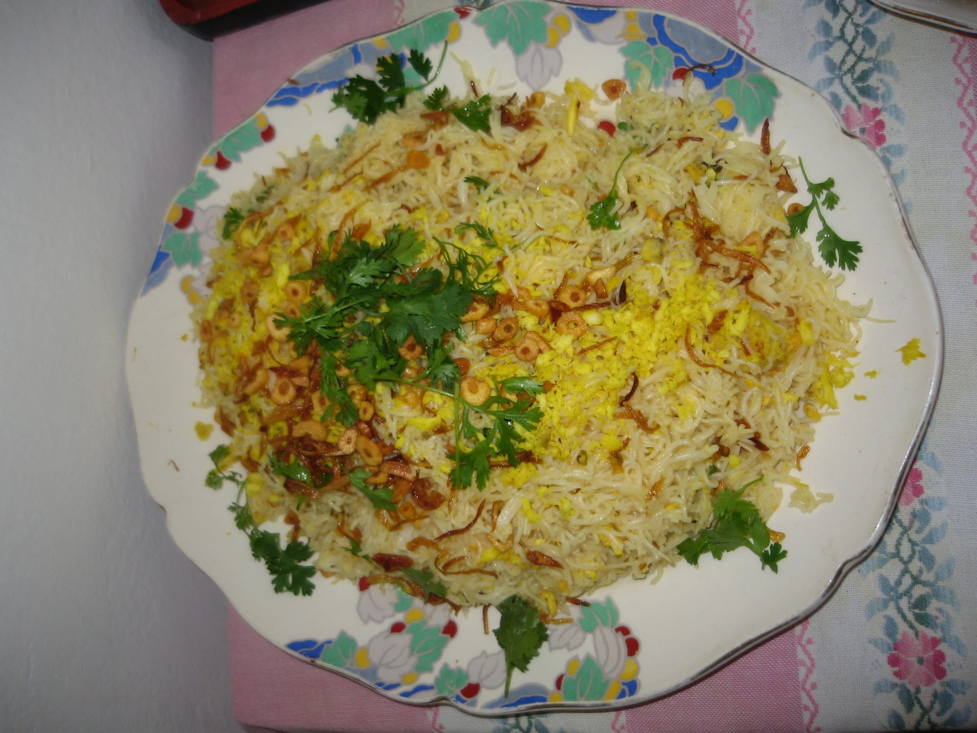 A plate of Rakhine mont di, fine rice noodles topped with fried garlic, coriander and egg.